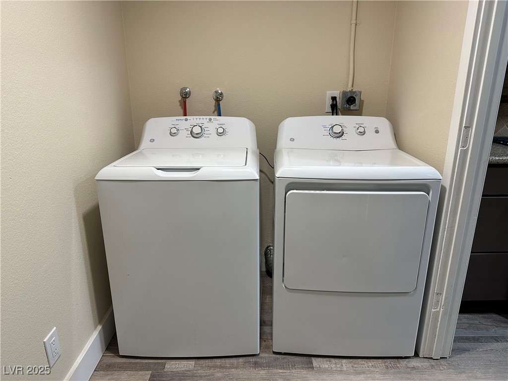117 Boysenberry Lane Henderson, NV 89074 - Photo 21 of 22 Laundry area featuring separate washer and dryer, a textured wall, and light wood-style floors