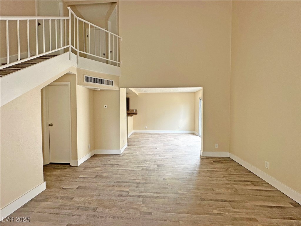 117 Boysenberry Lane Henderson, NV 89074 - Photo 7 of 22 Unfurnished living room featuring a towering ceiling and light wood-style floors