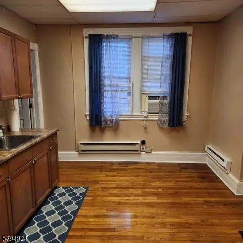 a kitchen with granite countertop wooden cabinets and a stove top oven