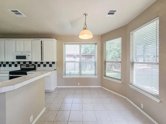 a kitchen with a refrigerator a stove top oven a sink and a window