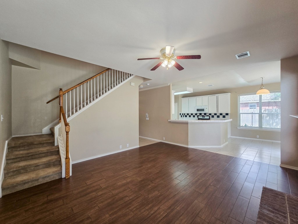 17692 Box Canyon Terrace Round Rock, TX 78681 - Photo 13 of 26 a view of an empty room with wooden floor and a ceiling fan