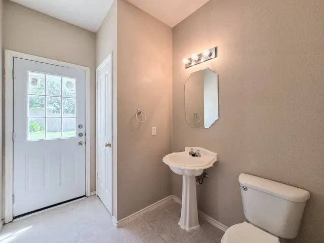 a bathroom with a toilet sink and mirror