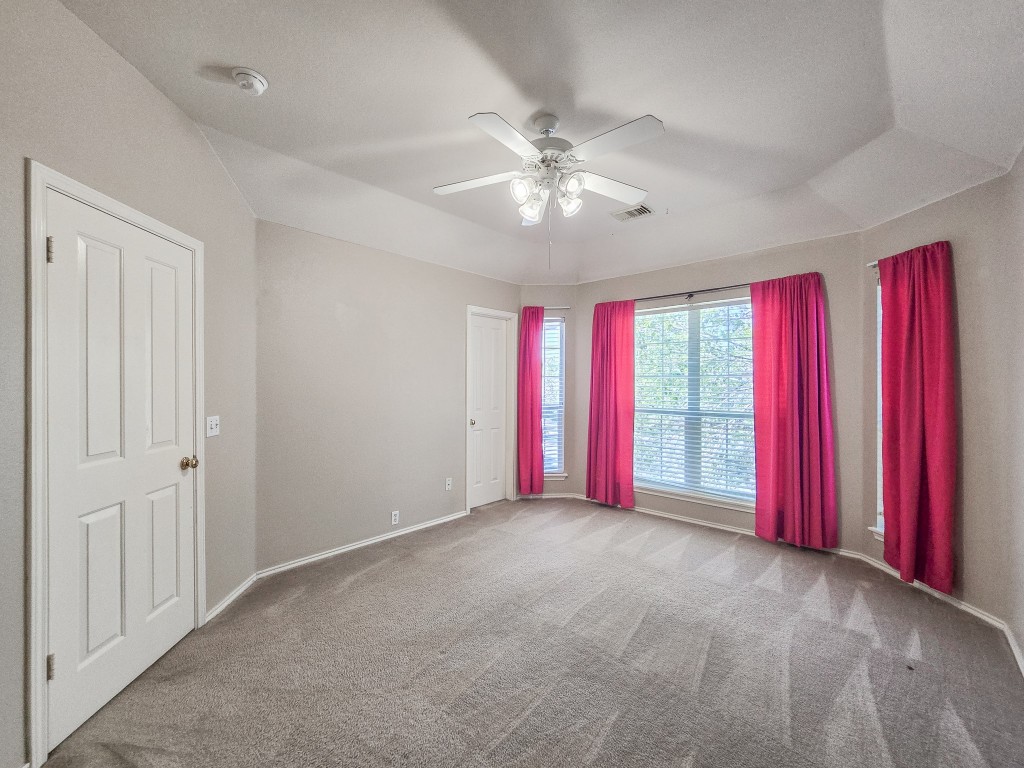 17692 Box Canyon Terrace Round Rock, TX 78681 - Photo 22 of 26 an empty room with windows and chandelier fan