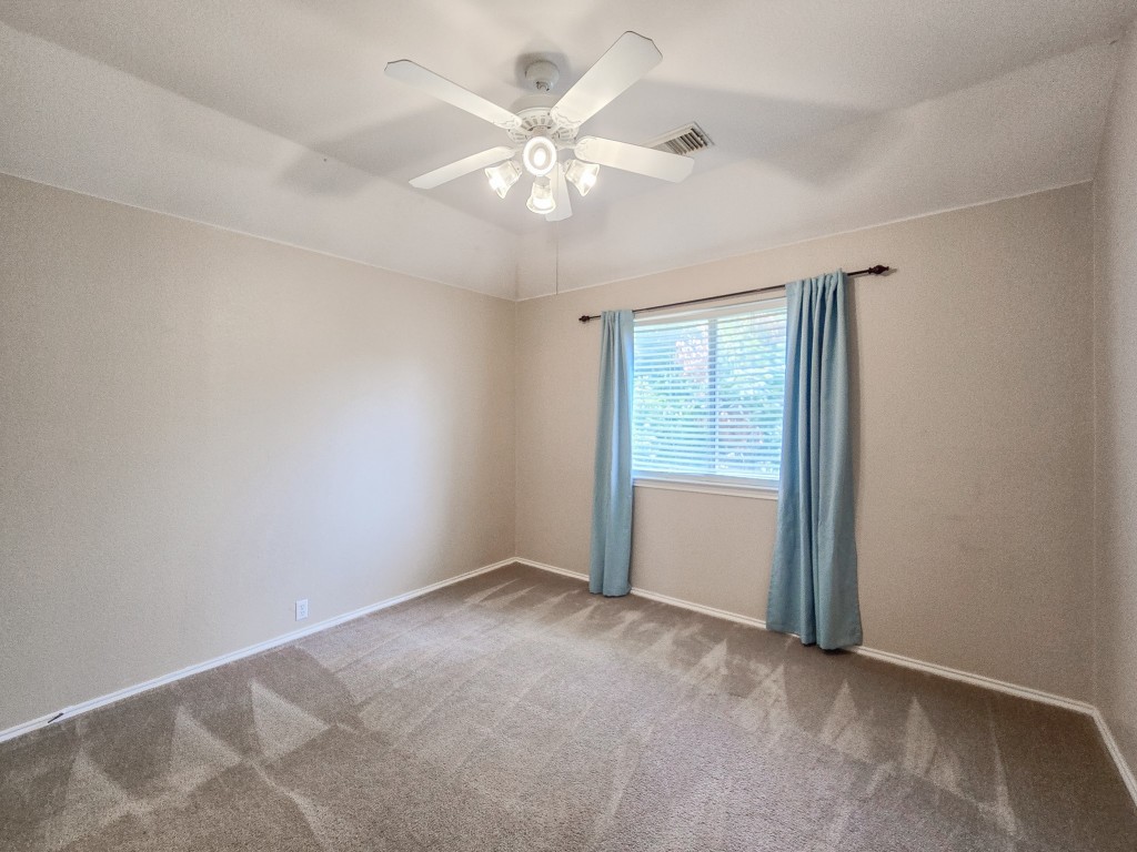 17692 Box Canyon Terrace Round Rock, TX 78681 - Photo 23 of 26 an empty room with windows and chandelier fan