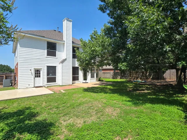a front view of a house with a yard and trees