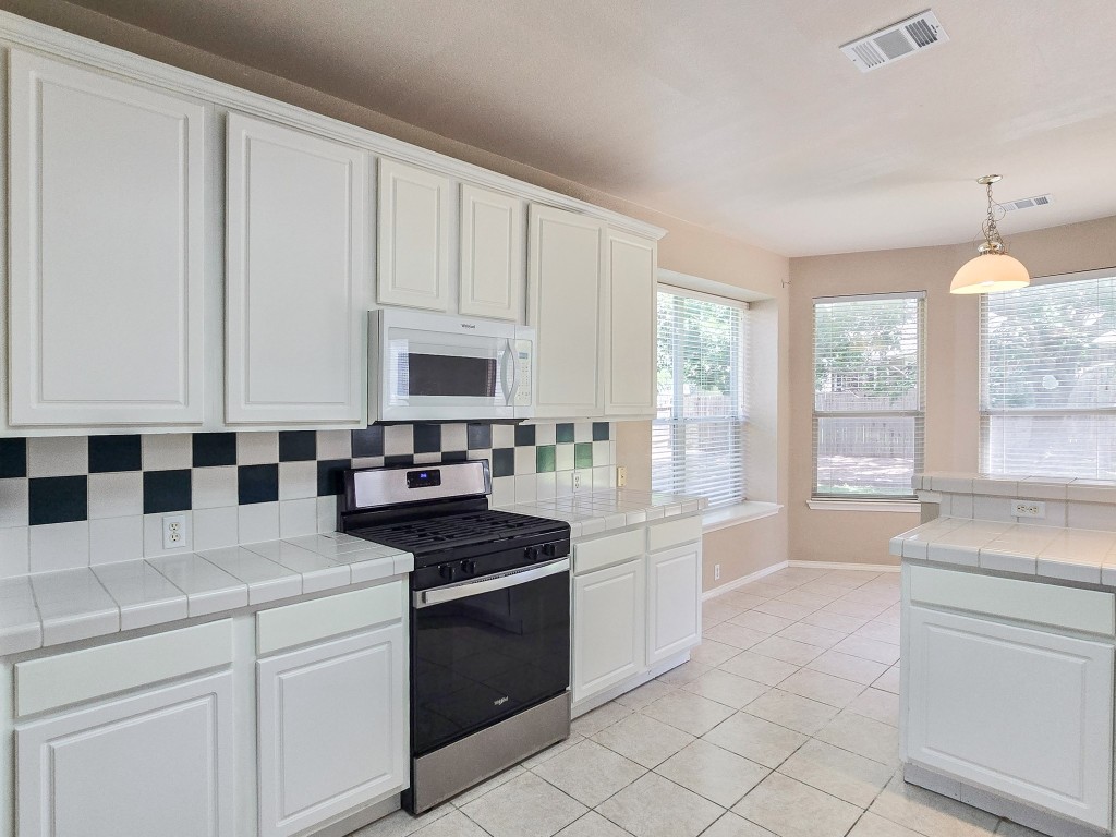 17692 Box Canyon Terrace Round Rock, TX 78681 - Photo 8 of 26 a kitchen with a stove a sink and a refrigerator