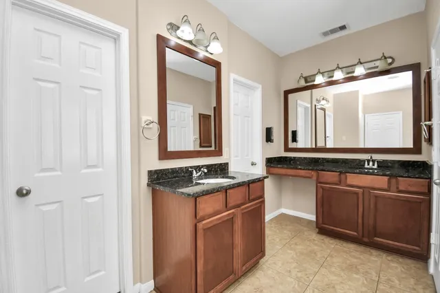 a bathroom with a granite countertop sink and a mirror