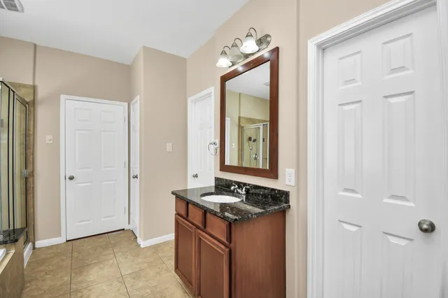 a bathroom with a granite countertop sink and a mirror