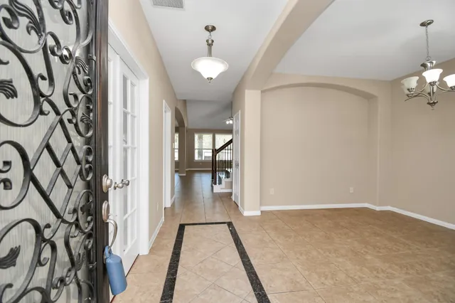 a view of a hallway with wooden floor and a chandelier