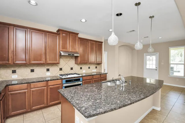 a kitchen with stainless steel appliances granite countertop a sink a counter space and cabinets