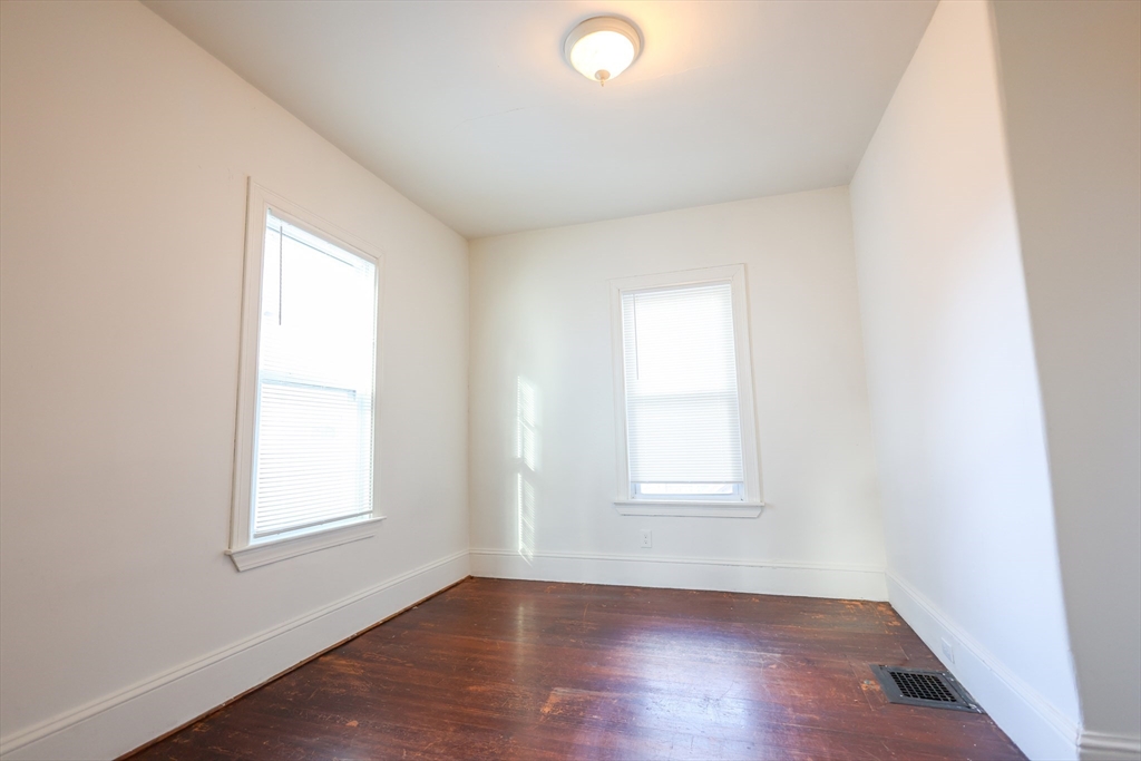 68 Newhall Street, Unit 68 Malden, MA 02148 - Photo 11 of 39 an empty room with wooden floor and windows