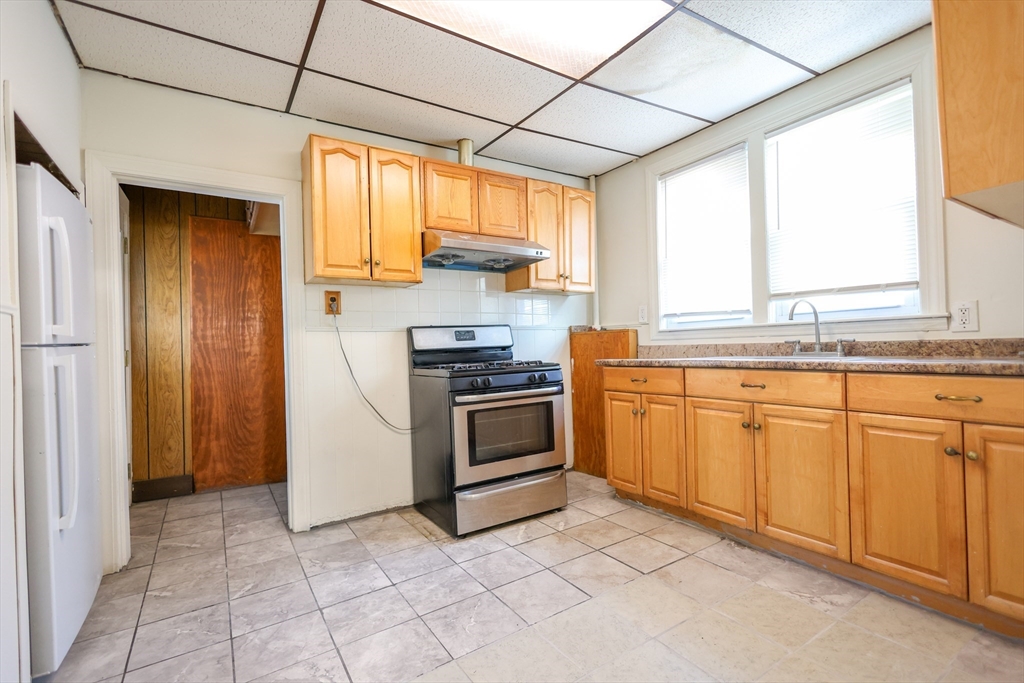 68 Newhall Street, Unit 68 Malden, MA 02148 - Photo 16 of 39 a kitchen with a stove a sink and a refrigerator