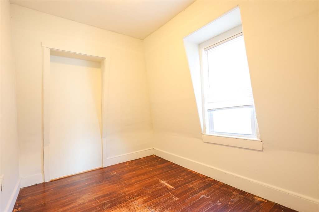 68 Newhall Street, Unit 68 Malden, MA 02148 - Photo 20 of 39 a view of an empty room with wooden floor and a window