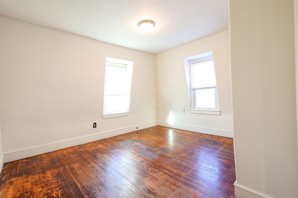 68 Newhall Street, Unit 68 Malden, MA 02148 - Photo 22 of 39 an empty room with wooden floor and windows