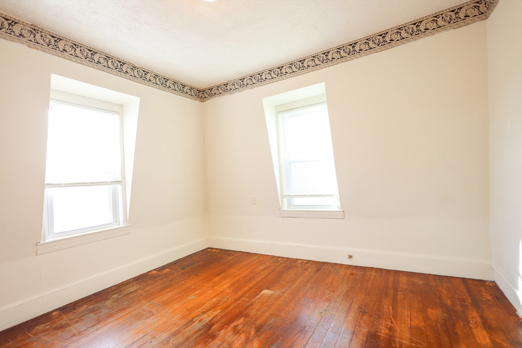 68 Newhall Street, Unit 68 Malden, MA 02148 - Photo 24 of 39 a view of an empty room with wooden floor and a window