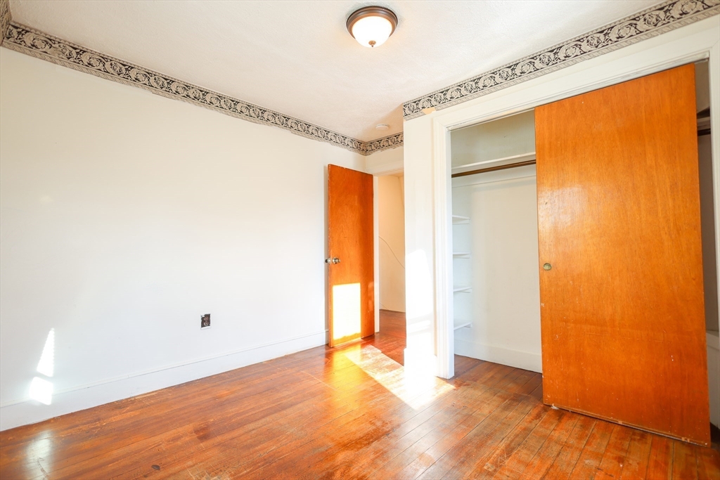 68 Newhall Street, Unit 68 Malden, MA 02148 - Photo 25 of 39 a view of an empty room with wooden floor and a window