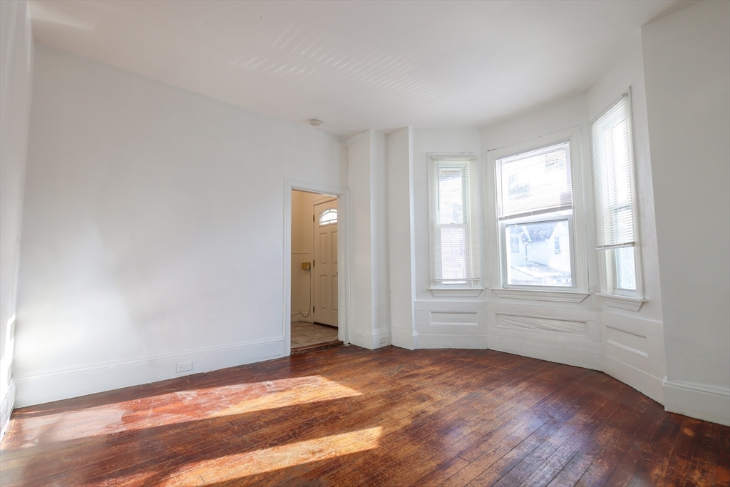68 Newhall Street, Unit 68 Malden, MA 02148 - Photo 8 of 39 an empty room with wooden floor and windows