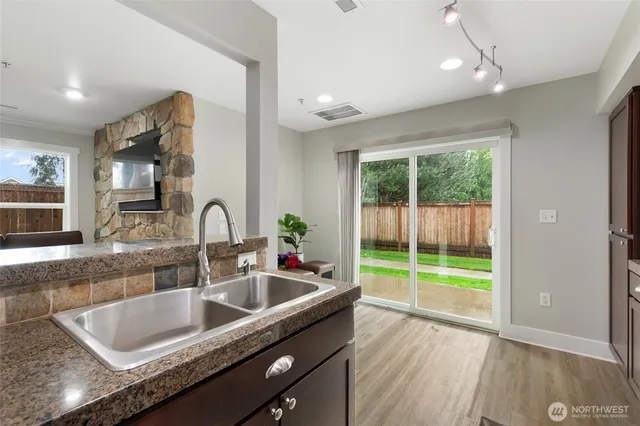 a kitchen with sink a faucet and potted plant with wooden floor