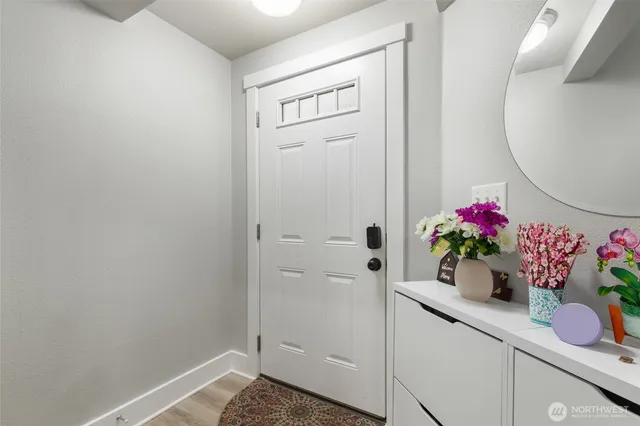 a bathroom with a potted plant on the counter and a wooden floor