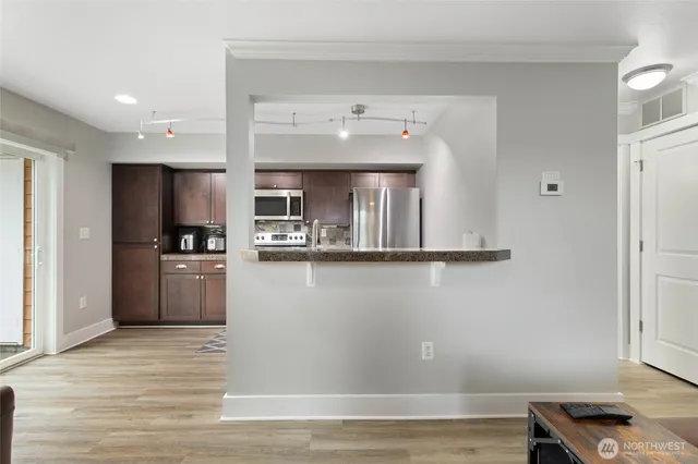 a kitchen with stainless steel appliances granite countertop a refrigerator and a stove