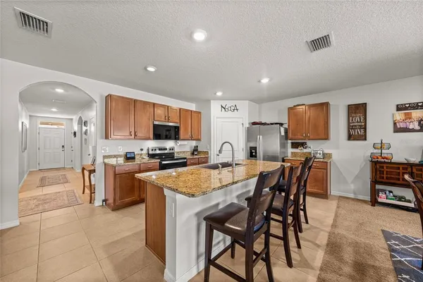 a large kitchen with cabinets table and chairs