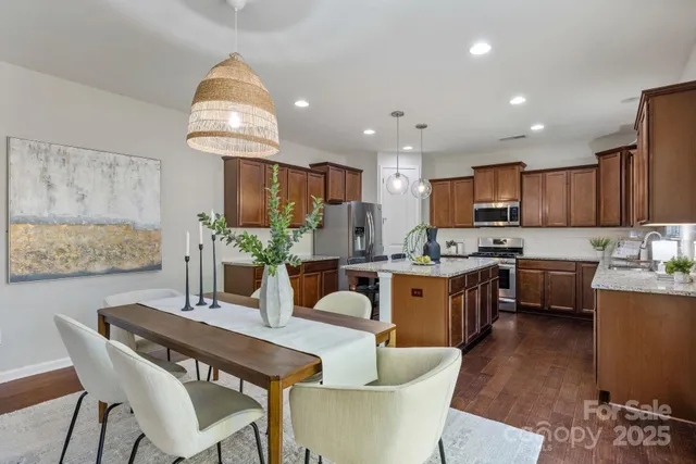 a kitchen with kitchen island granite countertop a sink a counter space appliances and cabinets