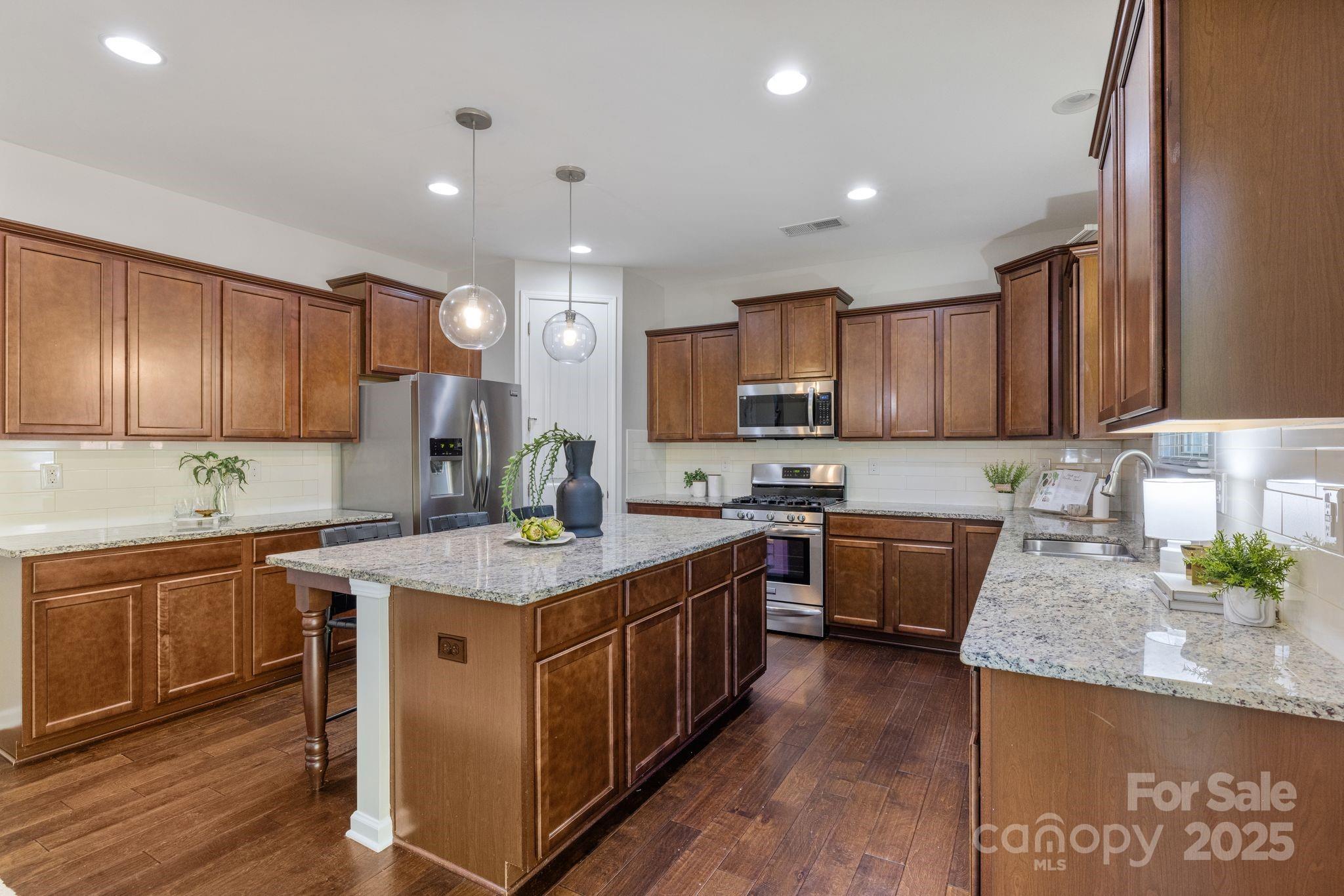 232 Morgan's Branch Road Belmont, NC 28012 - Photo 8 of 40 a kitchen with stainless steel appliances granite countertop wooden cabinets a sink and a stove