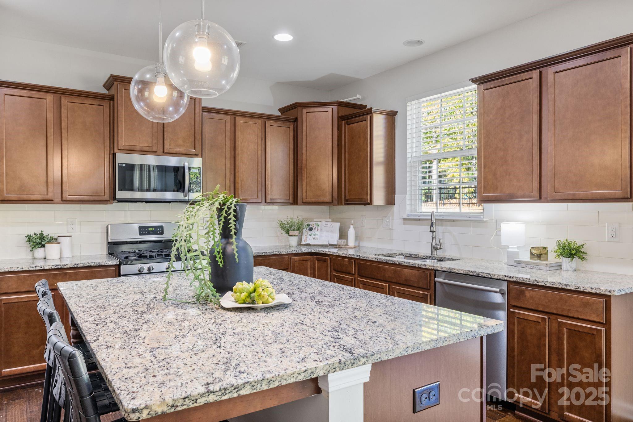 232 Morgan's Branch Road Belmont, NC 28012 - Photo 10 of 40 a kitchen with kitchen island granite countertop a sink a counter space appliances and cabinets