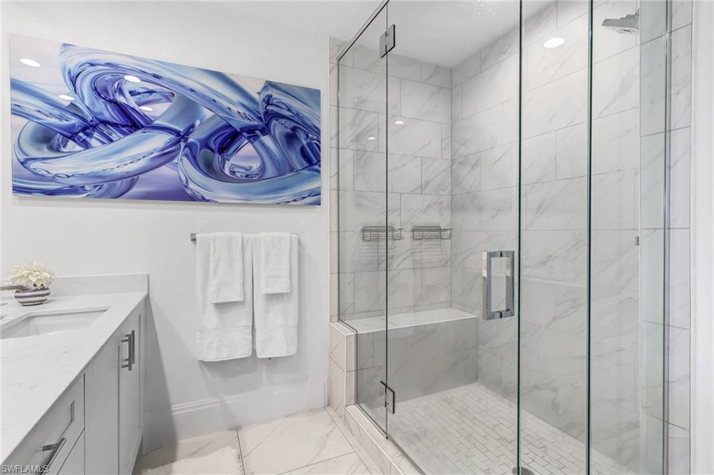1135 3rd Avenue South, Unit 415 Naples, FL 34102 - Photo 13 of 25 a bathroom with a granite countertop sink and a shower