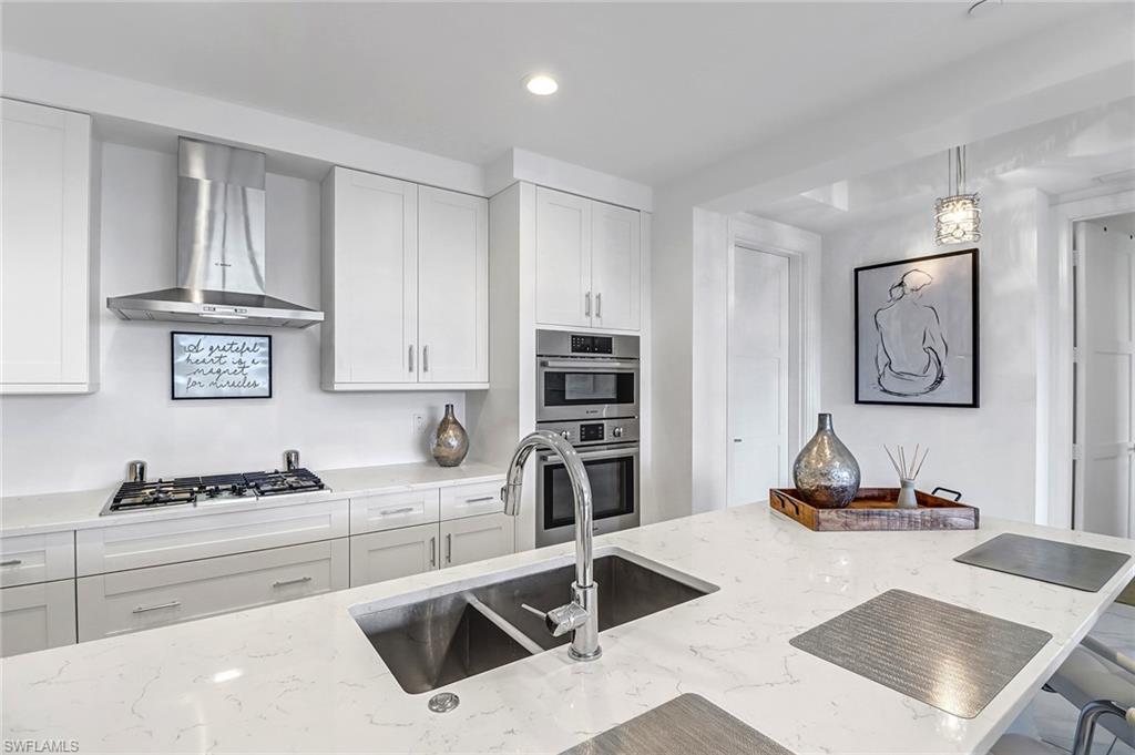1135 3rd Avenue South, Unit 415 Naples, FL 34102 - Photo 21 of 25 a kitchen with granite countertop a stove and a refrigerator