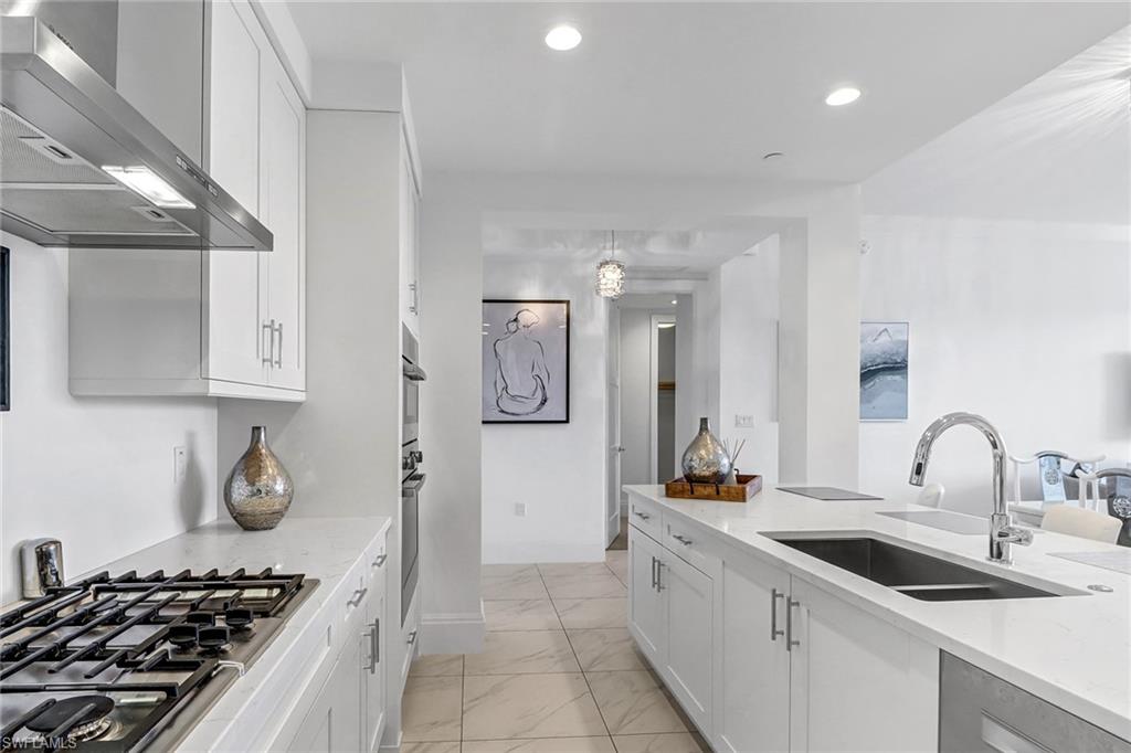 1135 3rd Avenue South, Unit 415 Naples, FL 34102 - Photo 3 of 25 a kitchen with a sink and a stove top oven