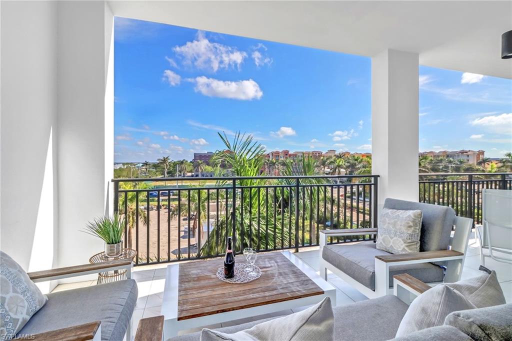 1135 3rd Avenue South, Unit 415 Naples, FL 34102 - Photo 5 of 25 a view of a balcony with couches and wooden floor