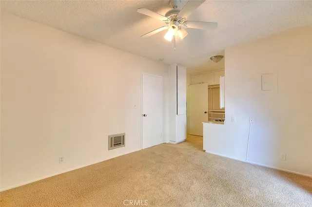 an empty room with a ceiling fan and a bathroom