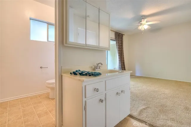 a bathroom with a granite countertop sink a toilet and a mirror
