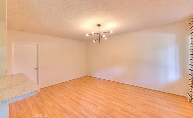 a view of a room with wooden floor and a ceiling fan