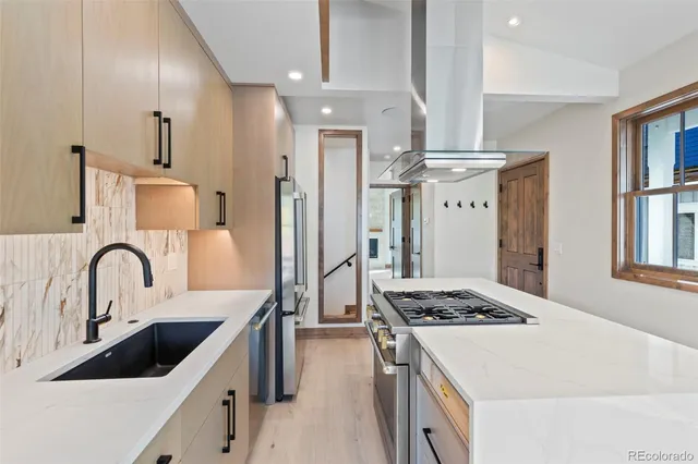 a kitchen with stainless steel appliances kitchen island a white stove a sink dishwasher and refrigerator with wooden floor