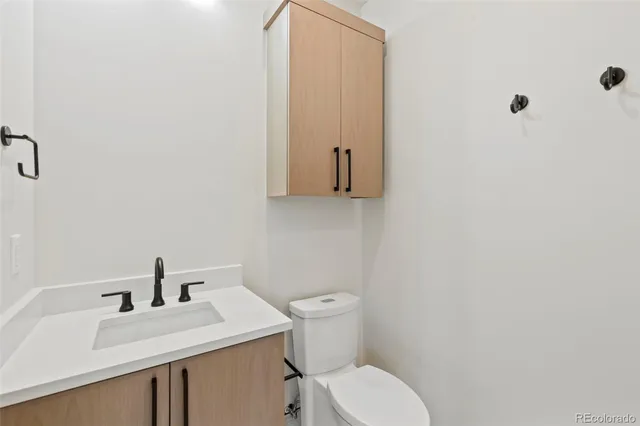 a bathroom with a sink a toilet and mirror