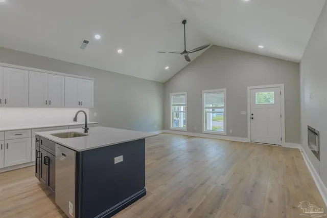 a kitchen with a sink a faucet cabinets and wooden floor