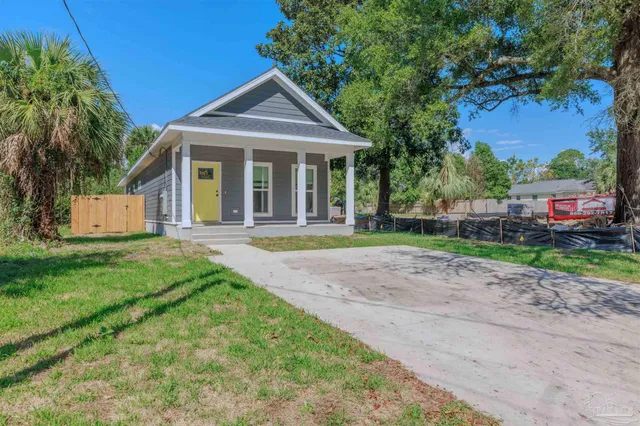 a front view of a house with a yard and trees
