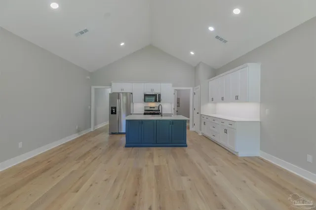 a large kitchen with stainless steel appliances granite countertop a large counter top and a stove top oven