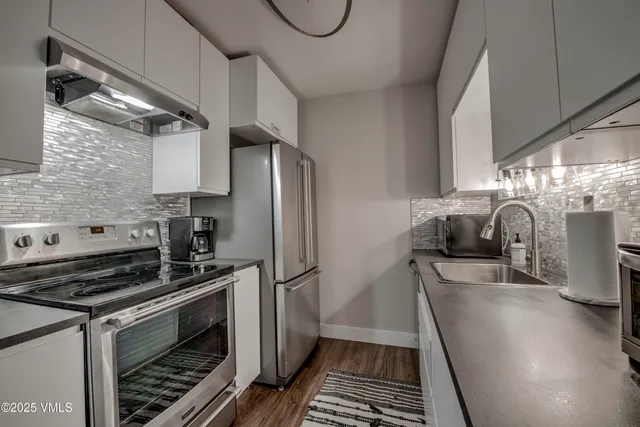 a kitchen with granite countertop a stove and a refrigerator