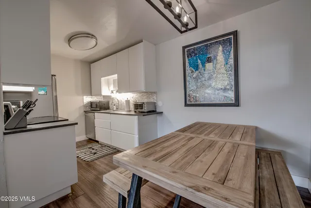 a kitchen with a table chairs refrigerator and cabinets
