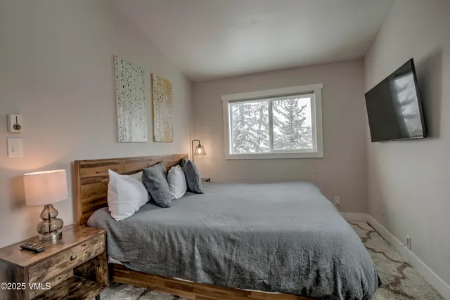 a bedroom with a bed and flat screen tv