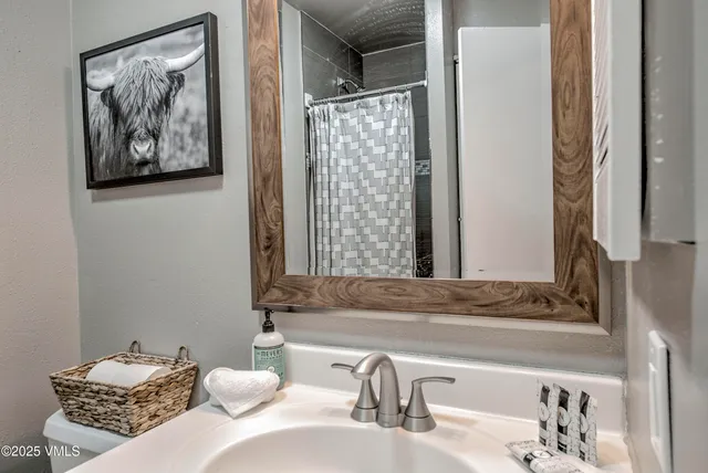 a bathroom with a granite countertop sink a mirror and a shower