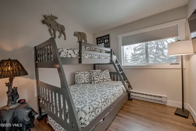 a bedroom with a bed and wooden floor