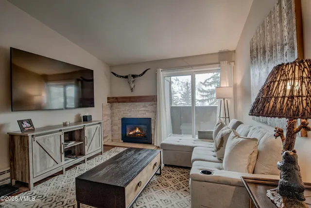 a living room with furniture a flat screen tv and a fireplace