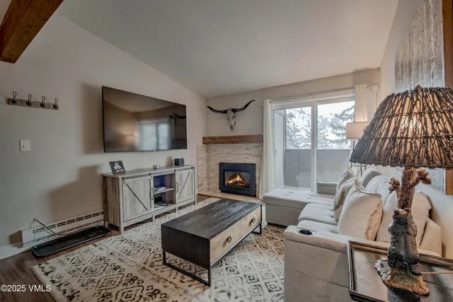 a living room with furniture a flat screen tv and a fireplace