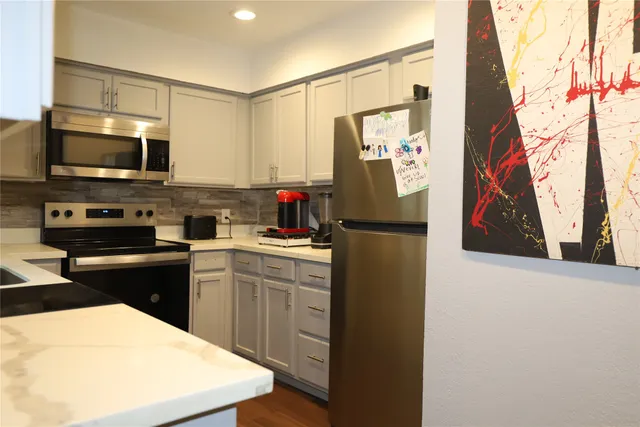 a kitchen with stainless steel appliances a refrigerator stove microwave and sink