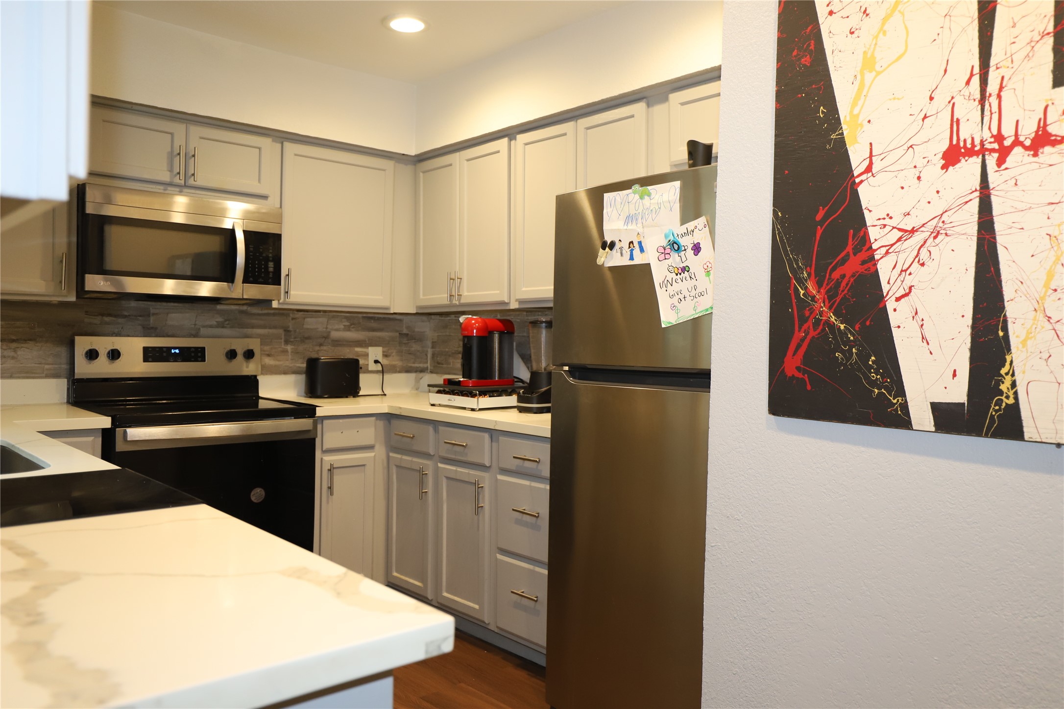 2103 Place Rebecca Lane, Unit D6 Houston, TX 77090 - Photo 6 of 31 a kitchen with stainless steel appliances a refrigerator stove microwave and sink