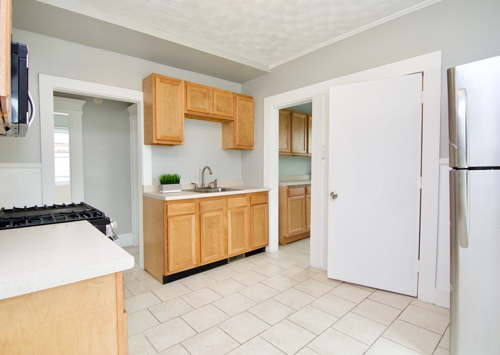 45 Malden Street Springfield, MA 01108 - Photo 3 of 30 a kitchen with a refrigerator a stove top oven a sink and dishwasher